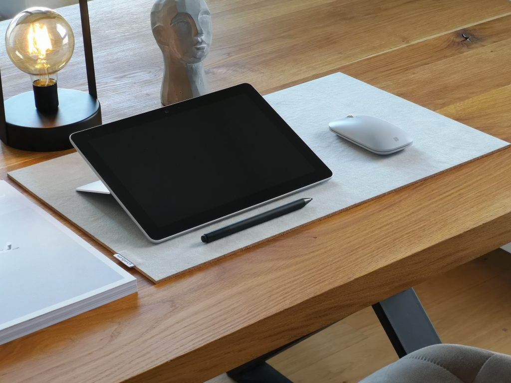 black ipad on brown wooden table